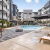 pool with fountains next to fire pit and lounge chairs